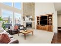 Comfortable living room with brick fireplace, large windows, plush seating, and a built-in entertainment center at 9556 Kemper Dr, Lone Tree, CO 80124