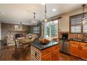 Open-concept kitchen with granite countertops, stainless steel appliances, and a view of the cozy fireplace at 16191 E Hinsdale Ln, Aurora, CO 80016