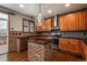 Well-equipped kitchen featuring brick accents, stainless steel appliances, and ample counter space for cooking at 16191 E Hinsdale Ln, Aurora, CO 80016