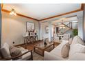 Inviting living room showcasing hardwood floors, modern furniture, and a view of the dining area and staircase at 16191 E Hinsdale Ln, Aurora, CO 80016