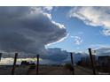 Backyard with a view of a stormy sky over the pasture from the pergola at 475 Hampstead Ave, Castle Rock, CO 80104