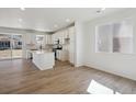 Open-concept kitchen with white cabinets, stainless steel appliances, and a large island with quartz countertops at 1318 Sienna Peak Cir, Erie, CO 80516