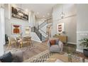 Virtually staged living room with hardwood floors, high ceilings, and a dining area at 15008 Clayton St, Thornton, CO 80602