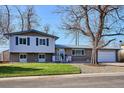 Charming two-story home boasts a well-maintained lawn, brick accents, and mature trees at 3406 E Fair Pl, Centennial, CO 80121