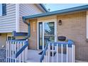 Inviting front porch with blue trim, brick accents, and a stylish entry door at 3406 E Fair Pl, Centennial, CO 80121