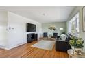 Spacious living room featuring hardwood floors, stylish decor, and a large television for entertainment at 3406 E Fair Pl, Centennial, CO 80121