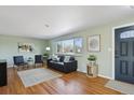 Inviting living room with hardwood floors, a modern sofa, and natural light streaming through the window at 3406 E Fair Pl, Centennial, CO 80121