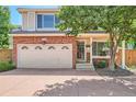Charming two-story home with a brick facade, attached garage, and mature tree at 1382 Braewood Ave, Highlands Ranch, CO 80129