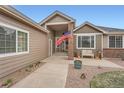 Inviting front porch with brick accents, flag, bench, and walkway, offering a warm welcome at 3562 Pine Meadow Ave, Parker, CO 80138