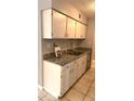 Kitchen counter with granite countertops, stainless steel sink, and white cabinets at 7495 E Quincy Ave # 205, Denver, CO 80237