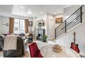 Cozy living room with fireplace, sectional sofa, access to kitchen, and adjacent staircase to upper level at 3449 W 63Rd Pl, Denver, CO 80221