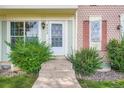 Charming entryway with a white door, well-manicured bushes, and decorative shutters at 9202 W Ontario Dr, Littleton, CO 80128
