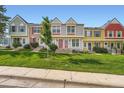 The row of townhomes showcases lovely curb appeal and is enhanced by a lush green lawn at 9202 W Ontario Dr, Littleton, CO 80128