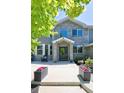 Charming home entrance with beautiful masonry, potted flowers and Adirondack chairs on the front porch at 14712 Kalamath Ct, Westminster, CO 80023