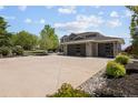 Charming home showcasing a wide driveway and a three-car garage complemented by stone and lush landscaping at 14712 Kalamath Ct, Westminster, CO 80023