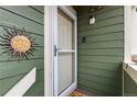 Close up of a green home's front door with a stylish decorative sun accent and modern doorbell at 19437 E Mann Creek Dr # A, Parker, CO 80134