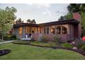 A beautiful home with a brick chimney, a well manicured lawn, lovely flowers, and mature trees at 8955 E 19Th Ave, Aurora, CO 80010