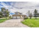 Charming two-story home featuring a three-car garage, well-manicured lawn, and inviting curb appeal at 2188 Savage Rd, Elizabeth, CO 80107