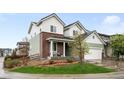 Beautifully landscaped front yard with a charming two-story home featuring mixed brick and siding exterior at 10906 Pastel Pt, Parker, CO 80134