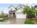 A beautiful two-story home with a two-car garage, mixed brick and siding exterior and a well-manicured front yard at 10906 Pastel Pt, Parker, CO 80134