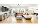 Spacious living room featuring wood floors, a large sofa, and multiple windows for lots of natural light at 10906 Pastel Pt, Parker, CO 80134