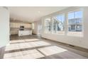 Spacious living room open to kitchen, featuring beautiful hardwood floors and ample natural light at 728 N Clubview St, Watkins, CO 80137