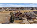 Aerial view of a brown single Gathering home in a neighborhood in a golf community at 21753 E Heritage Pkwy, Aurora, CO 80016