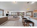 Open-concept living room featuring a fireplace, tile flooring and a view of the kitchen and backyard deck at 21753 E Heritage Pkwy, Aurora, CO 80016