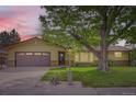Charming single-Gathering home featuring a large mature tree in the front yard and a two-car garage at 2310 Squires Ct, Longmont, CO 80501