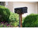 Curbside mailbox with house numbers surrounded by lush landscaping and vibrant flowers at 4034 S Atchison Way, Aurora, CO 80014