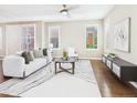 Bright living room featuring hardwood floors, large windows with shutters, and a stylish white sofa at 9236 E 52Nd Dr, Denver, CO 80238