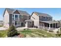 Expansive backyard featuring a patio, lush lawn, mature landscaping, and a covered porch area at 970 Inyokern Ct, Watkins, CO 80137
