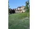Spacious front yard with manicured lawn leading up to a charming two-story home with a welcoming front porch at 970 Inyokern Ct, Watkins, CO 80137