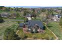 A sprawling estate featuring a well-manicured lawn and patio in a tranquil, scenic setting at 19770 E Geddes Pl, Centennial, CO 80016