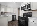 A kitchen with white cabinets, stainless steel appliances, and tiled backsplash at 6521 E 70Th Pl, Commerce City, CO 80022