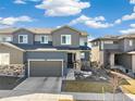 Charming two-story home featuring gray siding, a two-car garage, and a well-maintained front yard at 1526 Golden Sill Dr, Castle Pines, CO 80108