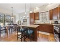 Open kitchen featuring a central island, stainless appliances, wood cabinets, and hardwood floors at 7444 E 9Th Ave, Denver, CO 80230