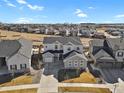 Aerial view of a home in a suburban community with landscaped yards and similar architectural styles at 1180 Ascent Trail Cir, Erie, CO 80516