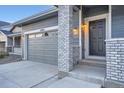 Close-up of home's front entrance, showcasing brickwork and garage at 26902 E Ellsworth Ave, Aurora, CO 80018