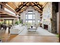 Bright living room features vaulted ceilings, a stone fireplace, hardwood floors, and large windows with beautiful views at 534 W Meadow Rd, Evergreen, CO 80439