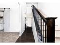 Inviting entryway with hardwood floors, a staircase, and a sliding barn door to the kitchen at 605 Wild Honey Dr, Berthoud, CO 80513