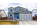 Two-story home with a blue front door and a well-maintained lawn creating a welcoming curb appeal at 605 Wild Honey Dr, Berthoud, CO 80513