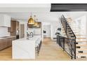 Open-concept kitchen with oversized island, marble countertop, statement lighting, and stainless steel appliances at 1665 S Fillmore St, Denver, CO 80210