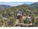 Scenic mountain home surrounded by trees featuring wood construction, solar panels, and a cozy guesthouse at 31911 Warrens Rd, Golden, CO 80403