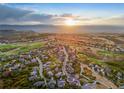 An aerial view of a housing community set among a golf course with scenic mountain views at 1222 Buffalo Ridge Rd, Castle Pines, CO 80108