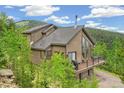 Mountain home features a deck, offering stunning views of the surrounding forest and hillside at 1758 Sinton Rd, Evergreen, CO 80439