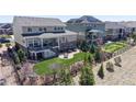 Backyard featuring an expansive artificial turf lawn, multiple seating areas, and lush landscaping at 8605 S Zante Ct, Aurora, CO 80016