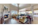 Open-concept living space featuring high ceilings, a fireplace, and seamless flow to the dining and kitchen areas at 8605 S Zante Ct, Aurora, CO 80016