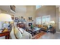 Bright living room with soaring ceilings, a cozy fireplace, and large windows with plantation shutters at 8605 S Zante Ct, Aurora, CO 80016