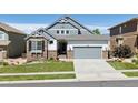 Charming two-story home featuring stone accents, a well-manicured lawn, and an attached two-car garage at 12189 Windy Trail Ln, Parker, CO 80138